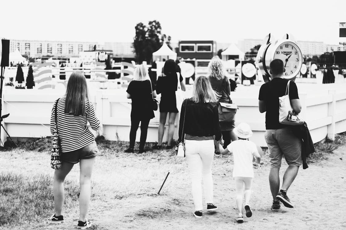 Grayscale Photo of People Gathering Near Clock