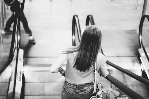 Monochrome Photography of Woman on the Escalator