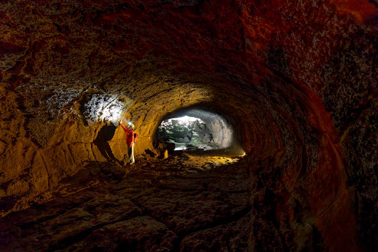 A Man Looking At The Wall Of A Cave