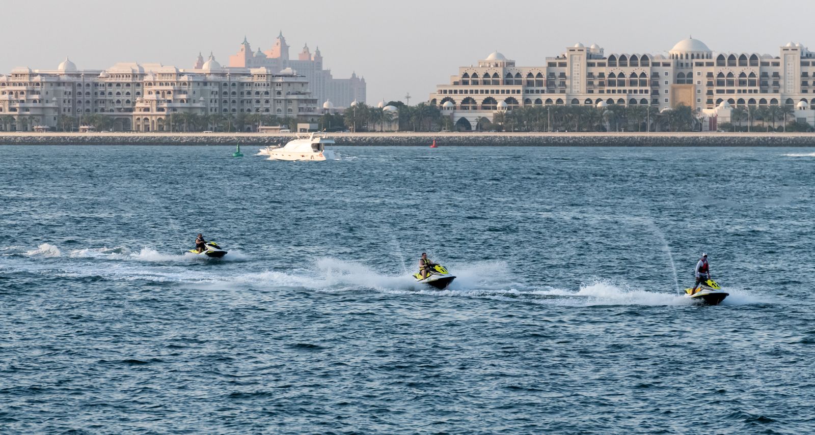 Three jet skis riding in line on the Gulf off the Dubai coast