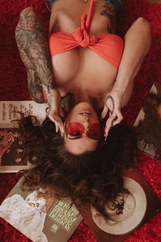 Woman in Red and White Polka Dot Bikini Lying on Brown and White Floral Textile