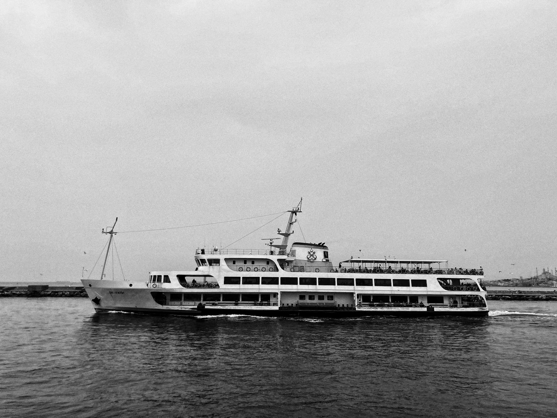 Black and white image of a ferry cruising across calm waters, capturing maritime elegance.
