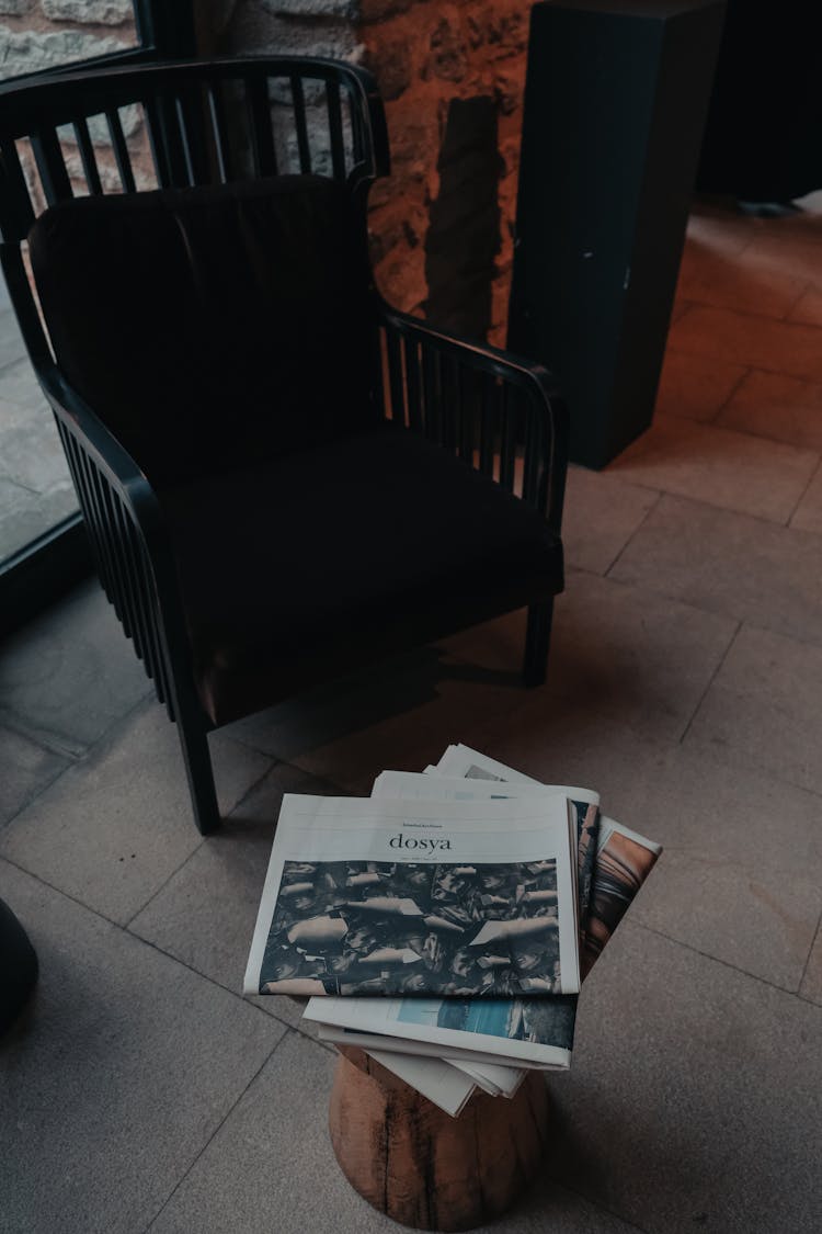 Empty Black Chair And Newspapers