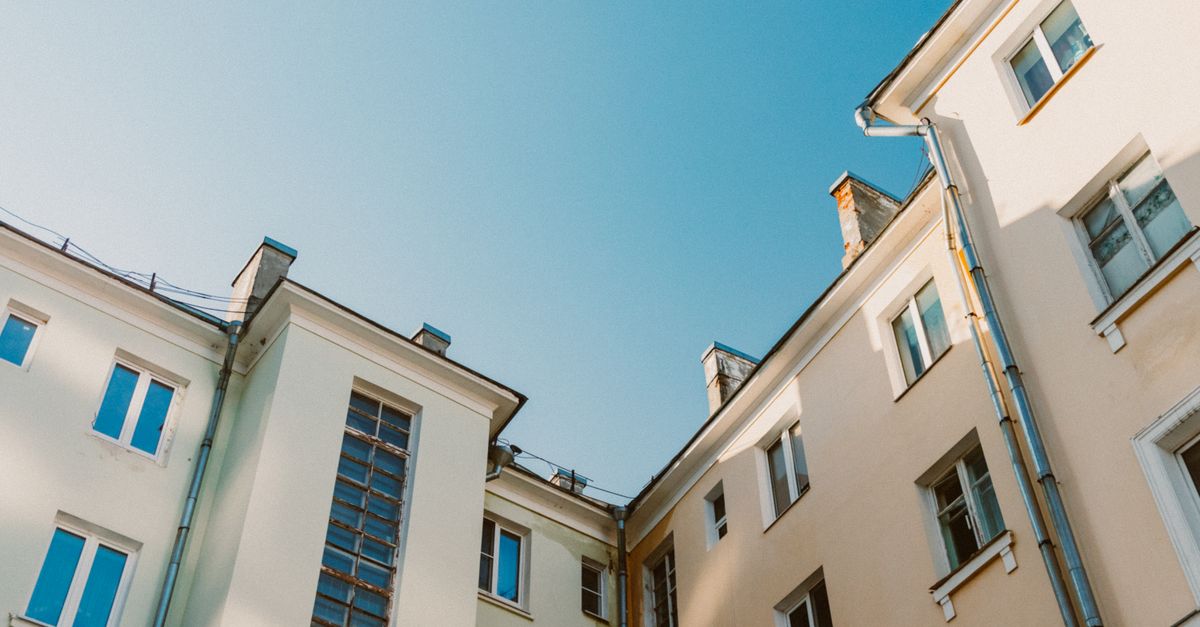 A low angle view of residential buildings with a clear blue sky in the background.