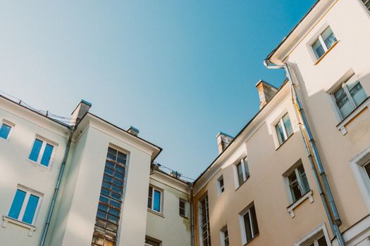 A low angle view of residential buildings with a clear blue sky in the background.