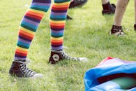 穿着彩虹条纹袜子和运动鞋，参加充满活力的户外骄傲庆祝活动