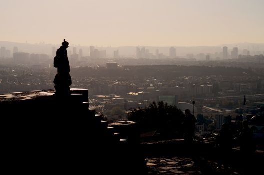 Silhouette of a person overlooking the Ankara skyline with a warm, moody sunset.
