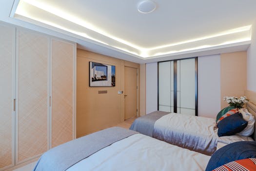 Contemporary bedroom featuring twin beds, elegant lighting, and stylish decor for a relaxing atmosphere.
