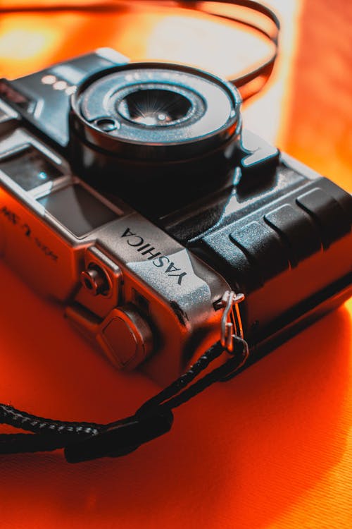 Close-Up Shot of a Camera on Orange Surface