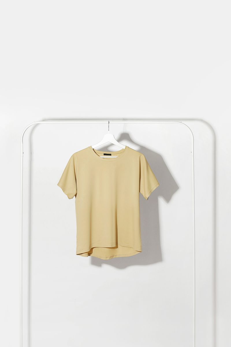 Beige shirt on a rail against a pale wall, photo by Marina Podrez on Pexels