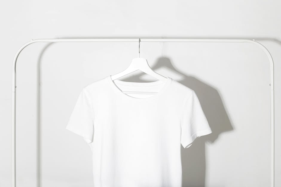 Two folded t-shirts, one black and one white, on a plain background in a minimalist style.