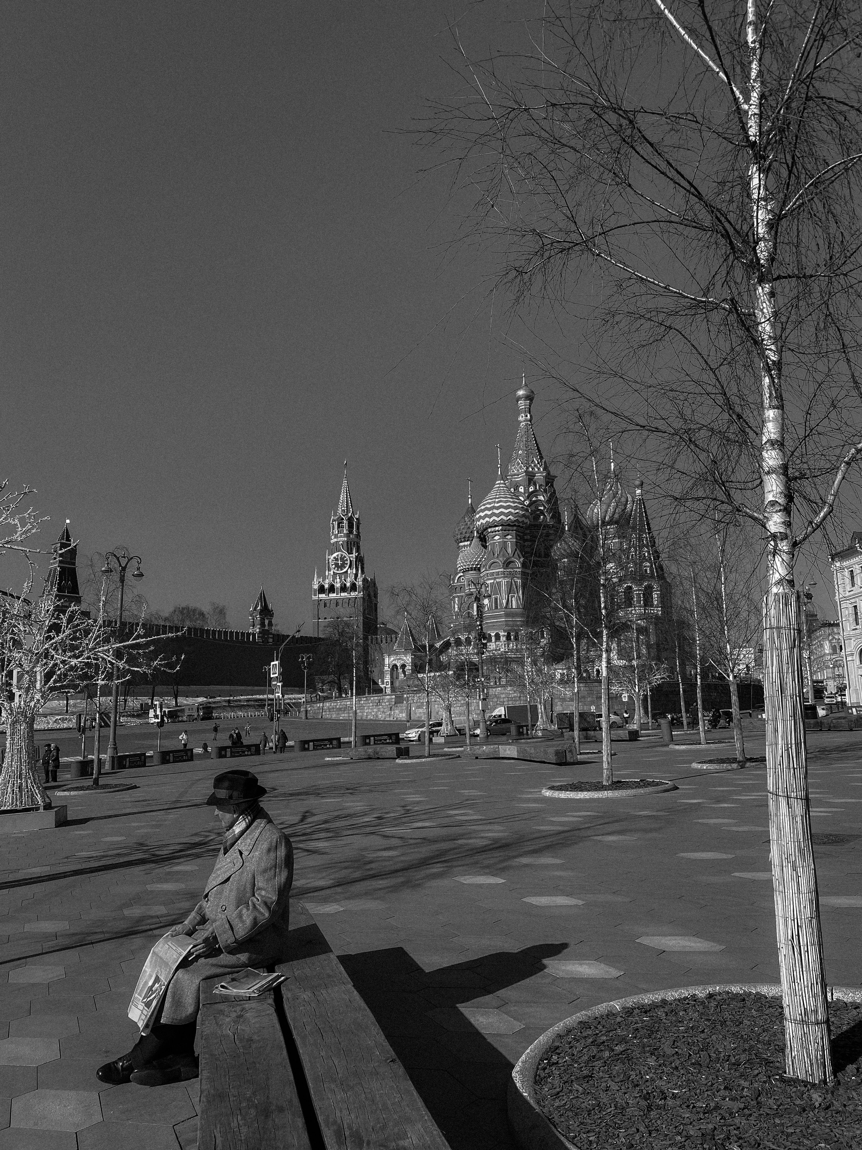 Black and white image of an elderly man in a Moscow park near St. Basil’s Cathedral.