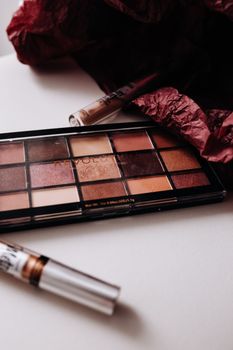 Vibrant eyeshadow palette with brushes on a minimalist white background.
