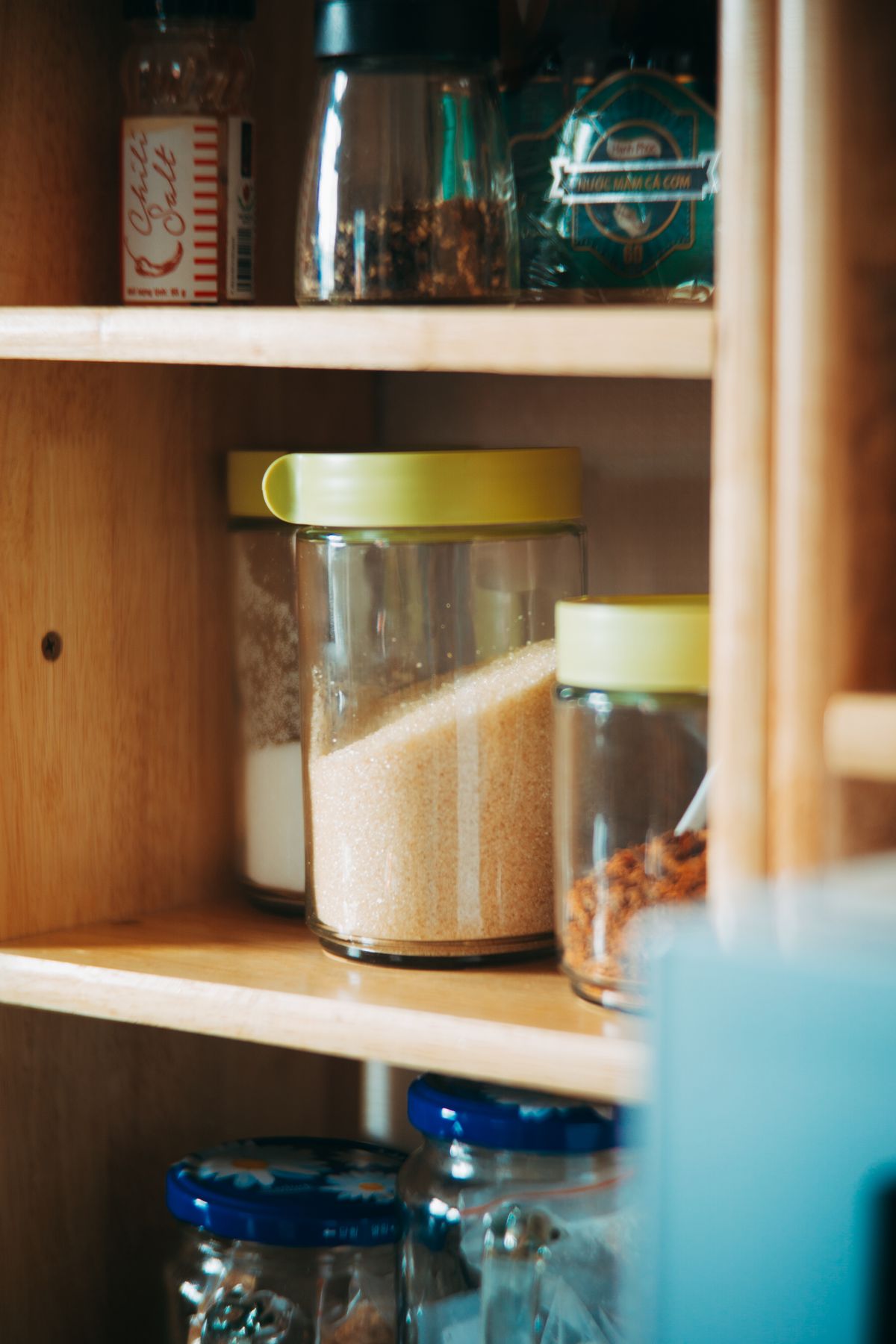 Neatly arranged pantry shelves with glass food storage jars