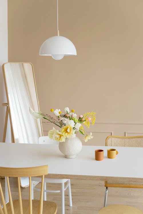 White Flower Vase with Yellow and White Flowers on White Table