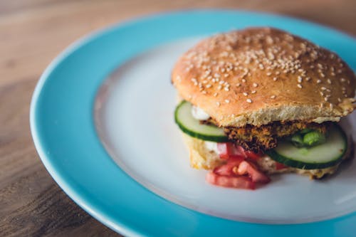 Free Burger With Lettuce and Tomato on White and Red Round Plate Stock Photo
