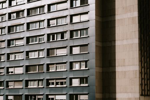 Free Close-up of a modern concrete building facade highlighting windows and geometric shapes. Stock Photo
