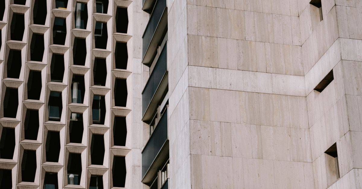 Close-up view of a contemporary building facade with unique geometric designs and windows.