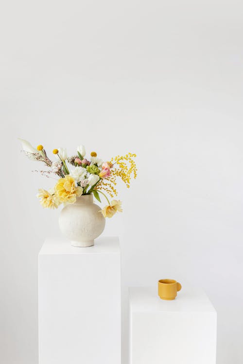Free A Vase with Flowers and Yellow Mug on a Platform Stock Photo