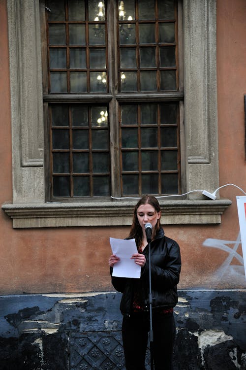 Woman in Black Jacket Holding White Paper