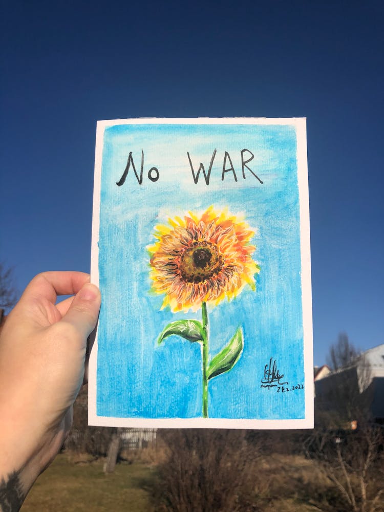 Person Holding A Paper With Sunflower Drawing