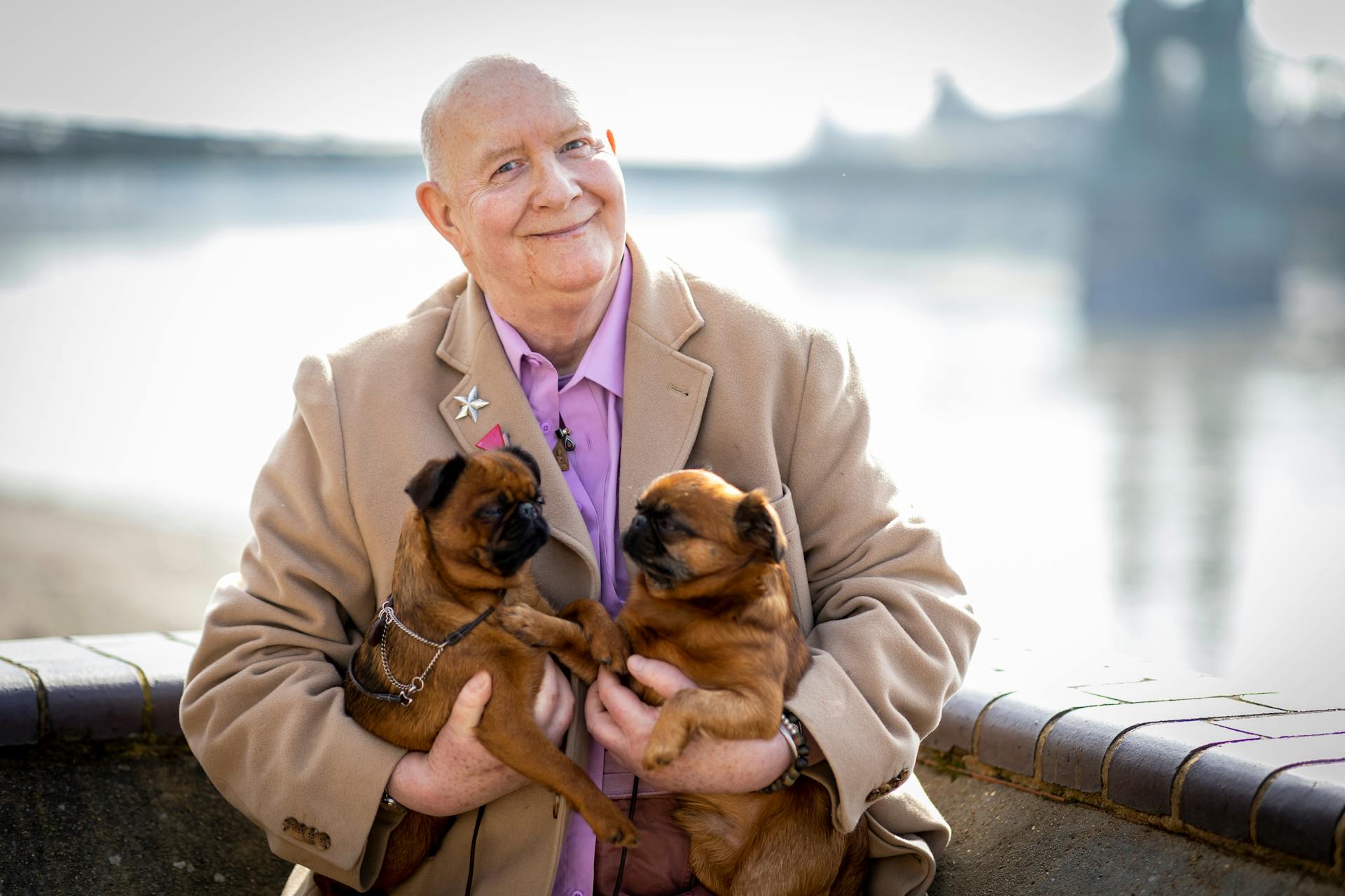 Elderly Man in Suit Holding Brown Pugs