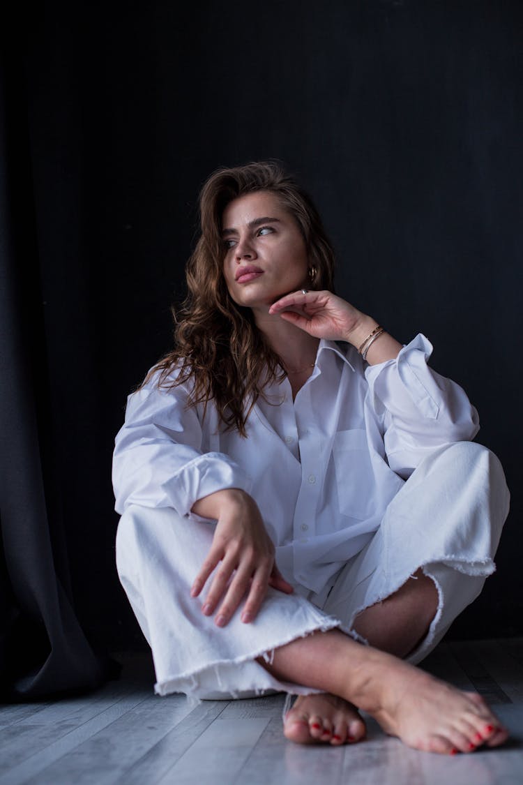 Woman In Loose Fitting Clothes Sitting On Floor