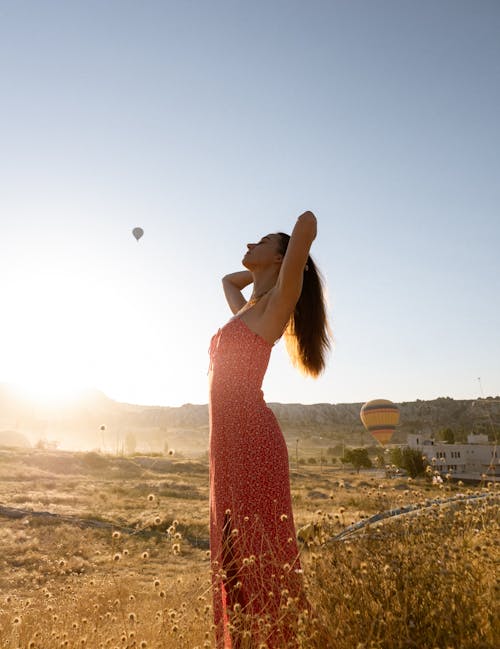 Free Woman Standing on the Background of Hot Air Balloons in Cappadocia Stock Photo