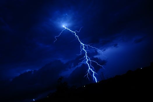 A powerful lightning bolt illuminating a dark nighttime sky in Georgetown, Texas.