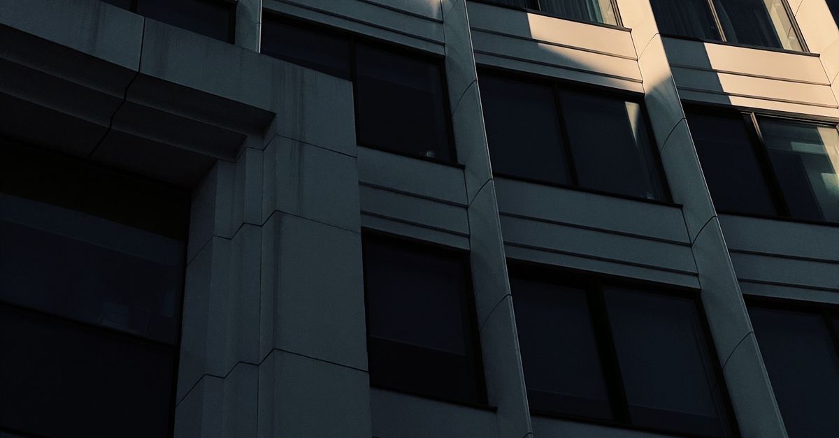 Stone City Building with Windows in Shadow · Free Stock Photo