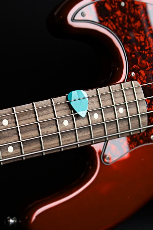 Free Teal Guitar Pick on String Instrument Stock Photo