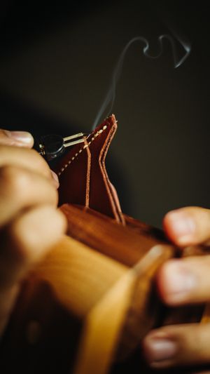 Craftsman using a burner tool on leather