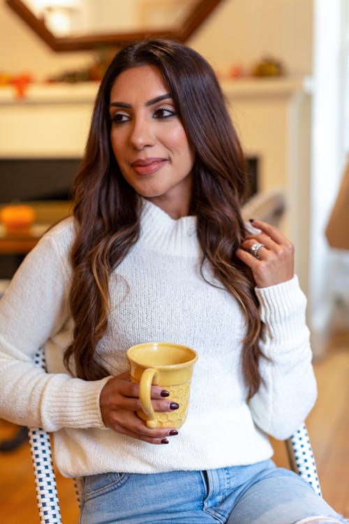 Woman in White Sweater Holding a Ceramic Mug