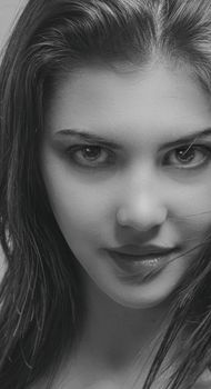 Black and white close-up of a young woman's intense gaze in a classic portrait style.