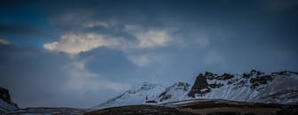 一座孤独的教堂坐落在白雪皑皑的群山之中，云层笼罩