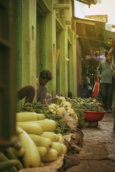 Vibrant street vendor market with fresh vegetables in a bustling alley.