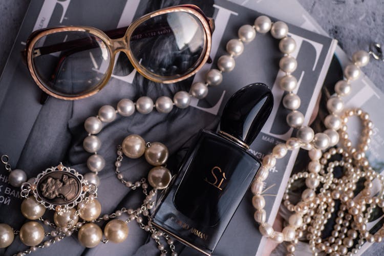 Giorgio Armani Bottle Surrounded By Pearl Accessories And Sunglasses