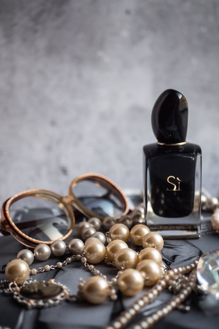 Giorgio Armani Bottle Surrounded By Pearl Accessories And Eyeglasses