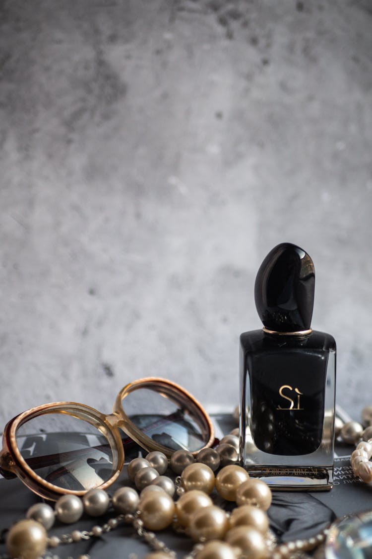 Giorgio Armani Bottle Surrounded By Pearl Accessories And Eyeglasses