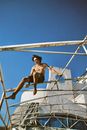 Young Man Sitting on an Old Rusty Ship