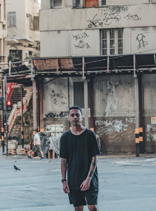 Free Man standing on graffiti-adorned street in Rio, embodying urban culture and style. Stock Photo