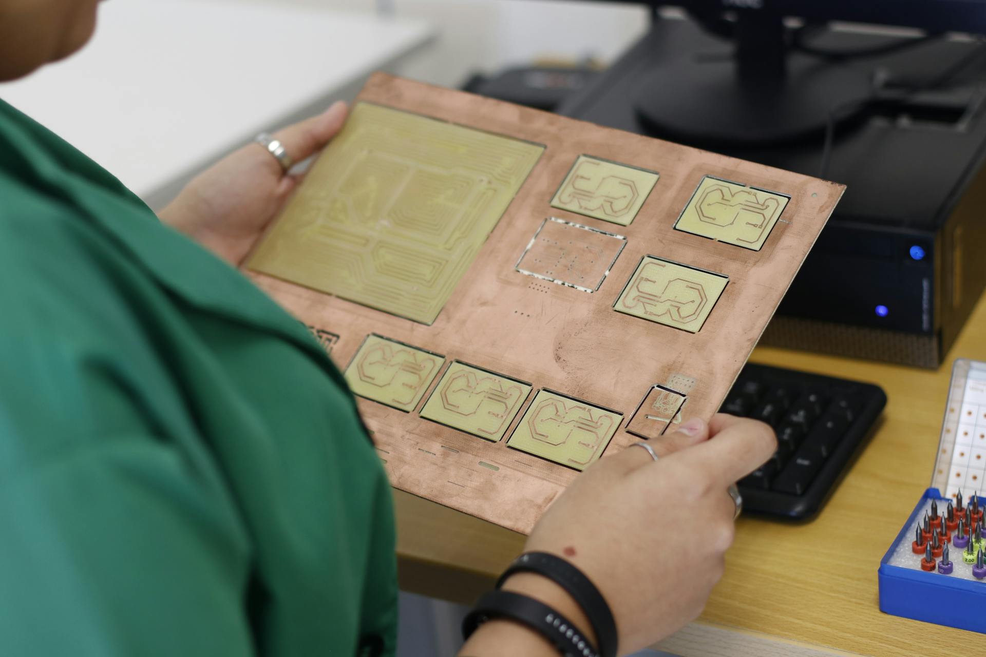 A technician examines a printed circuit board in a modern electronics lab.