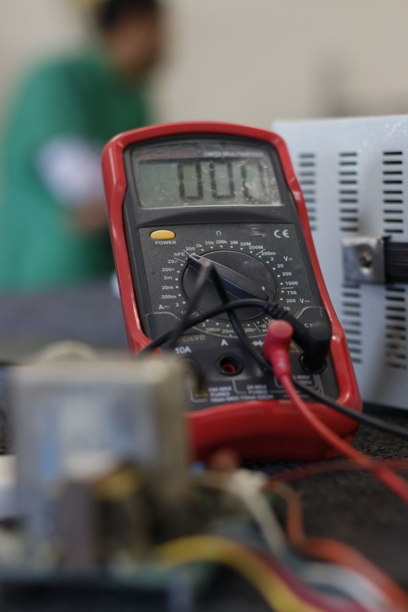 Digital multimeter used for electrical testing on a workbench