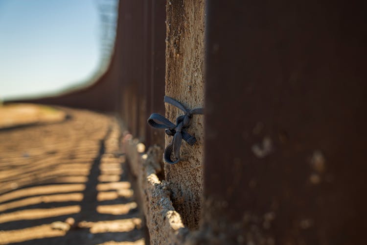 Shoelace On Column At Border Wall