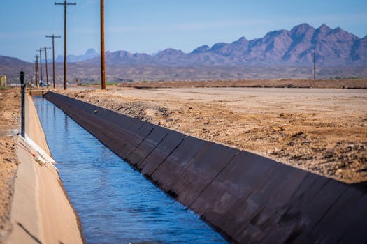 Serene canal in Yuma, Arizona, with desert mountains in the background.