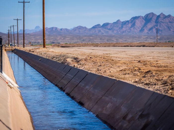 Serene canal in Yuma, Arizona, with desert mountains in the background.
