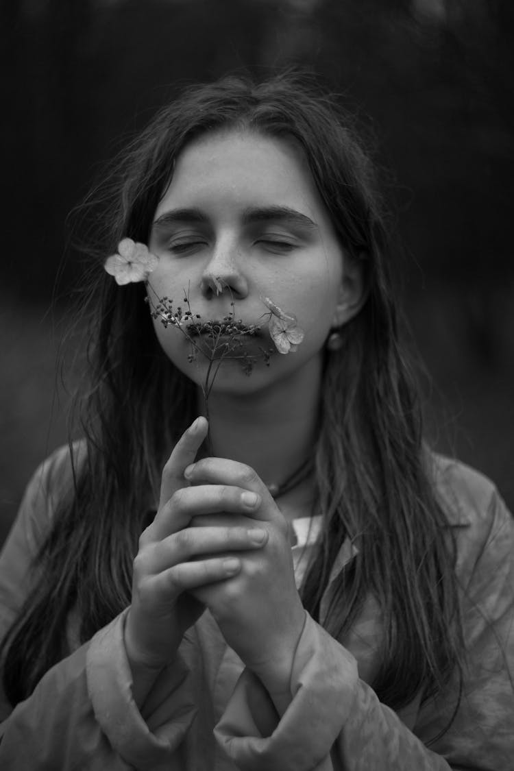 Black And White Portrait Of Young Girl Smelling Flower