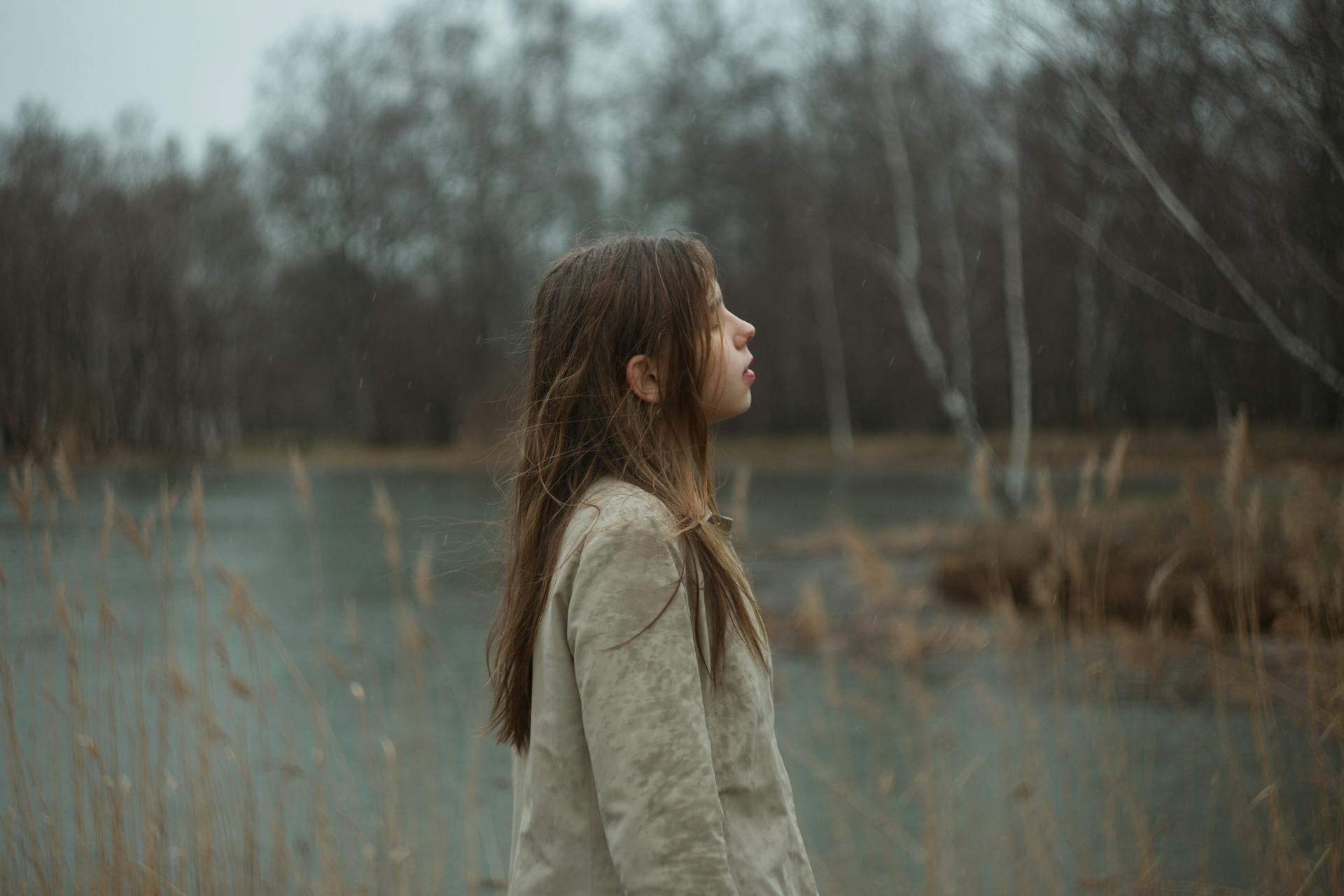 Young Girl Standing on Lake Shore in Forest