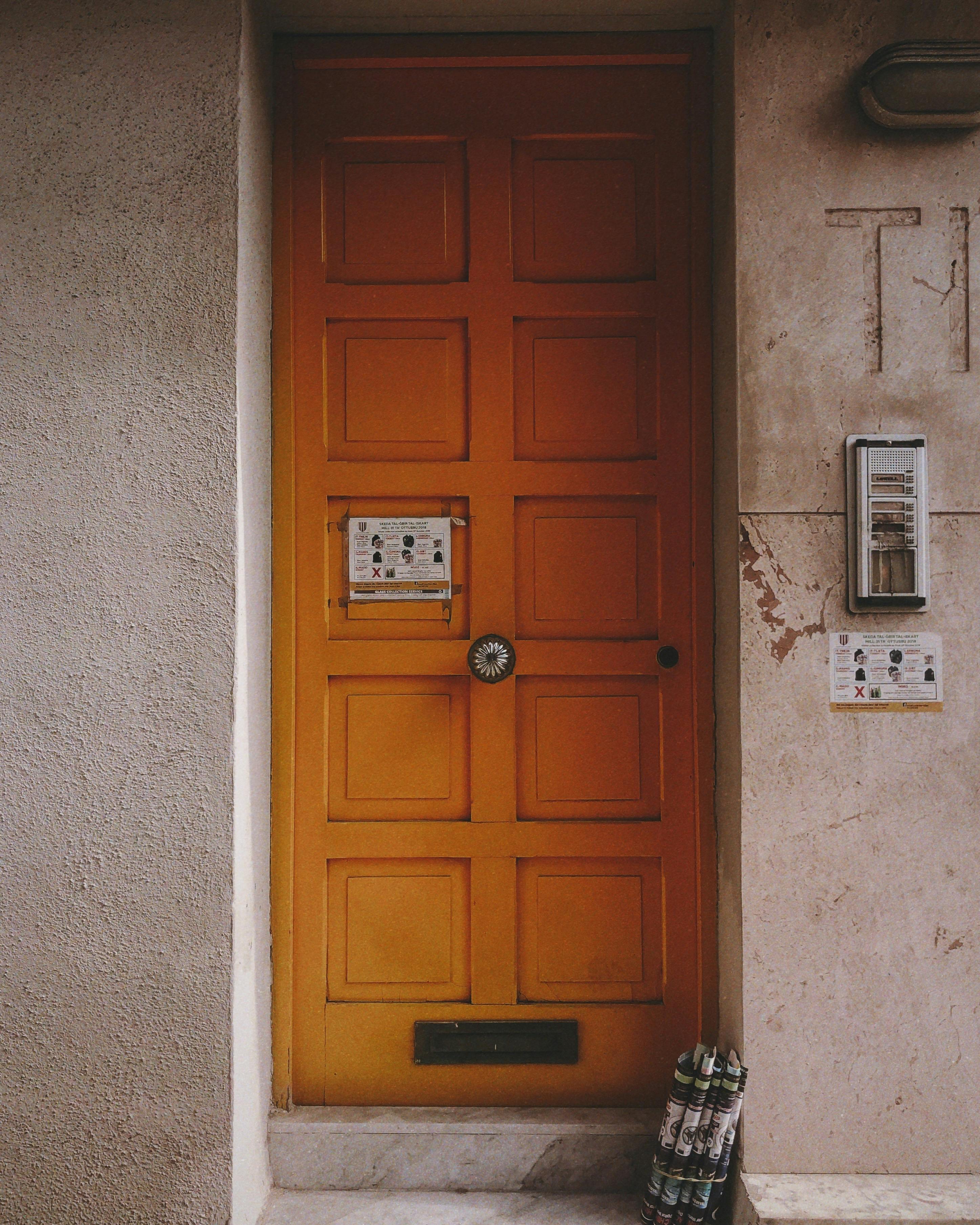 brown wooden door on white concrete wall