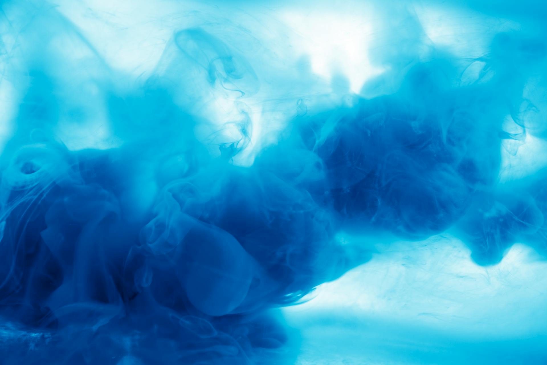 Captivating abstract image of blue ink swirling in water, creating a dreamlike underwater effect.